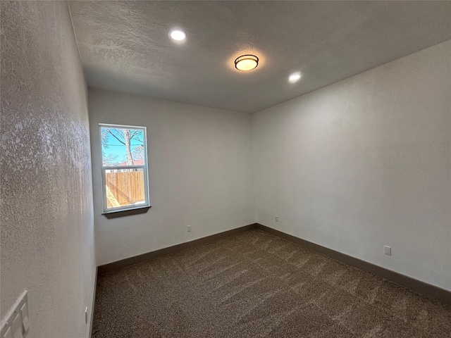 carpeted spare room with a textured ceiling