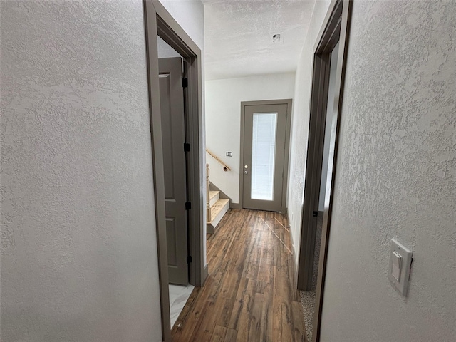 hallway with dark wood-type flooring and a textured ceiling