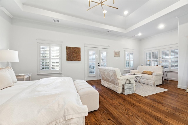 bedroom featuring multiple windows, access to exterior, dark wood-type flooring, and a raised ceiling