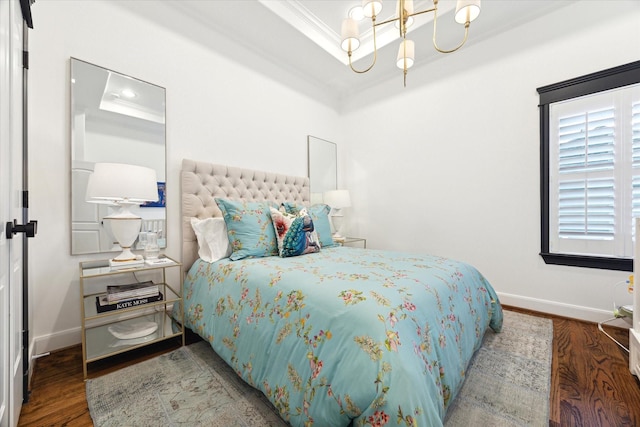 bedroom featuring crown molding, wood-type flooring, a tray ceiling, and a notable chandelier