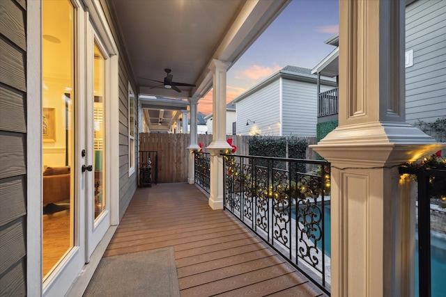 balcony at dusk featuring ceiling fan