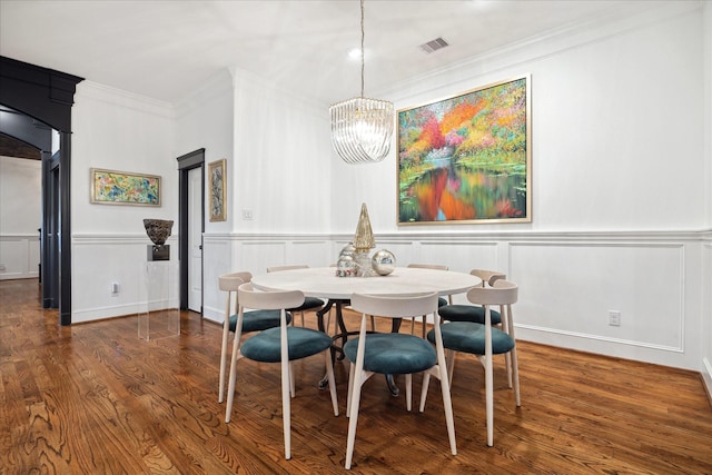 dining space featuring ornamental molding, dark wood-type flooring, and a chandelier