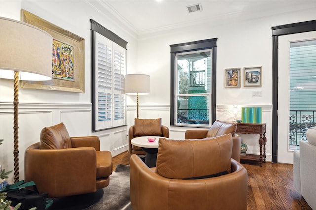 sitting room featuring ornamental molding and dark hardwood / wood-style floors