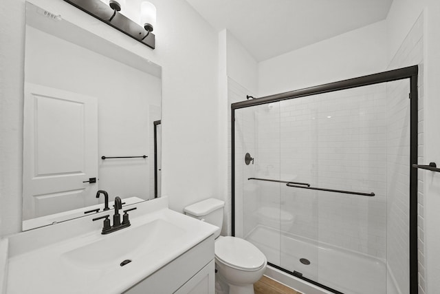 bathroom with visible vents, a stall shower, vanity, and toilet