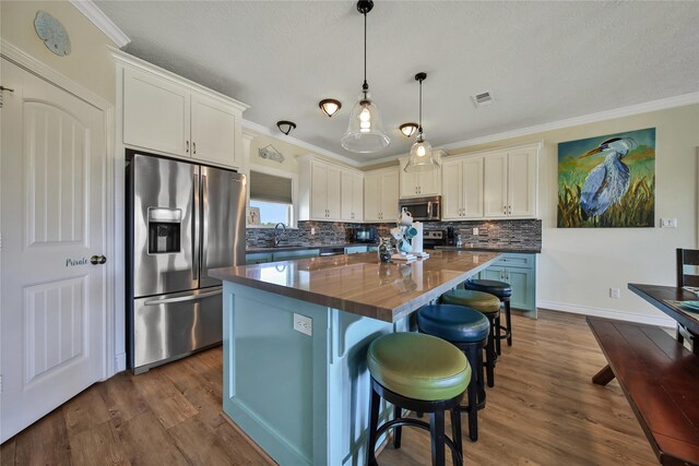 kitchen with a kitchen island, pendant lighting, a breakfast bar area, stainless steel appliances, and dark wood-type flooring