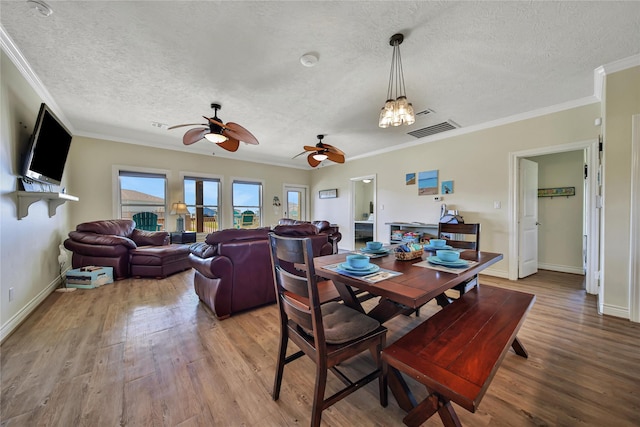 dining room with crown molding, hardwood / wood-style floors, ceiling fan, and a textured ceiling