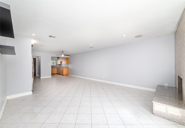 unfurnished living room featuring ceiling fan, light tile patterned floors, and a fireplace