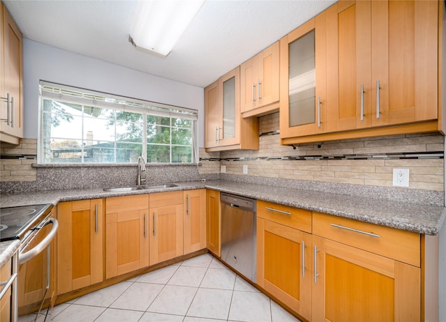 kitchen featuring sink, decorative backsplash, light tile patterned floors, light stone counters, and stainless steel appliances