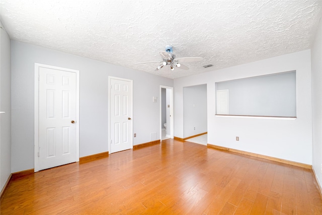 empty room featuring wood-type flooring, a textured ceiling, and ceiling fan