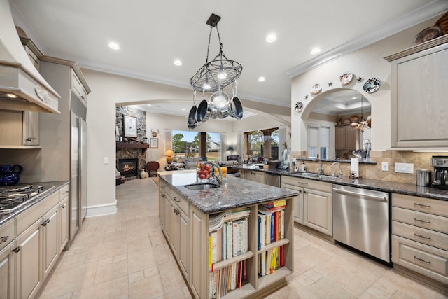 kitchen with stainless steel appliances, decorative light fixtures, sink, and a kitchen island