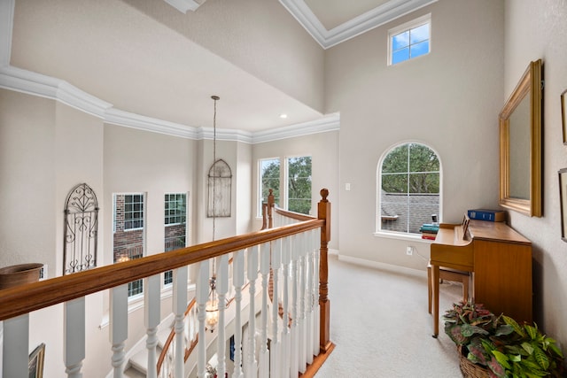 hall featuring light colored carpet, ornamental molding, and a notable chandelier