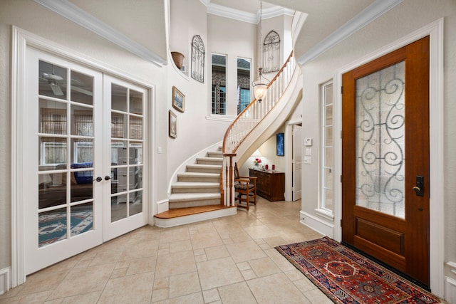 entrance foyer with crown molding and french doors