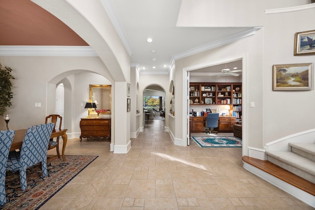 foyer entrance featuring ceiling fan, ornamental molding, and built in desk