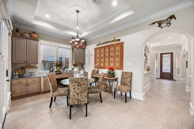 dining area featuring crown molding, plenty of natural light, and a tray ceiling