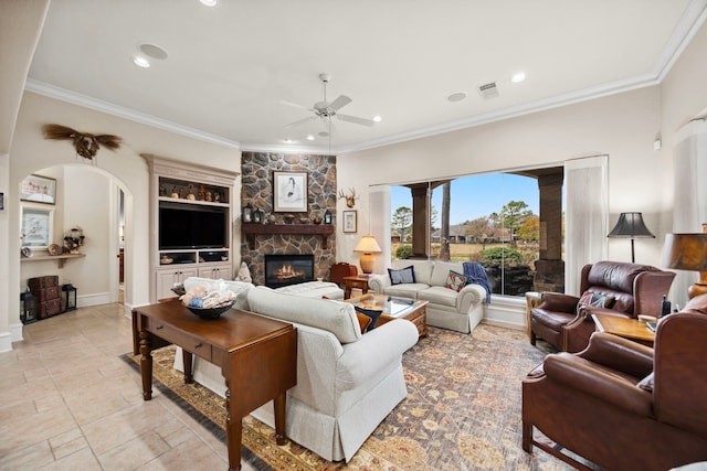 living room featuring crown molding, ceiling fan, and a fireplace