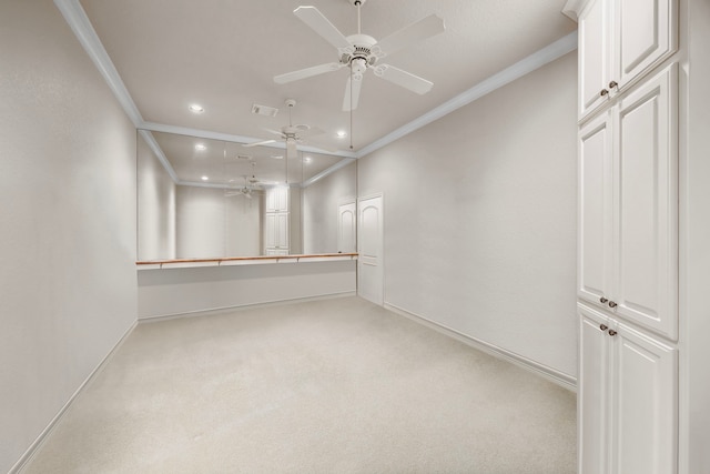 spare room featuring crown molding, light colored carpet, and ceiling fan