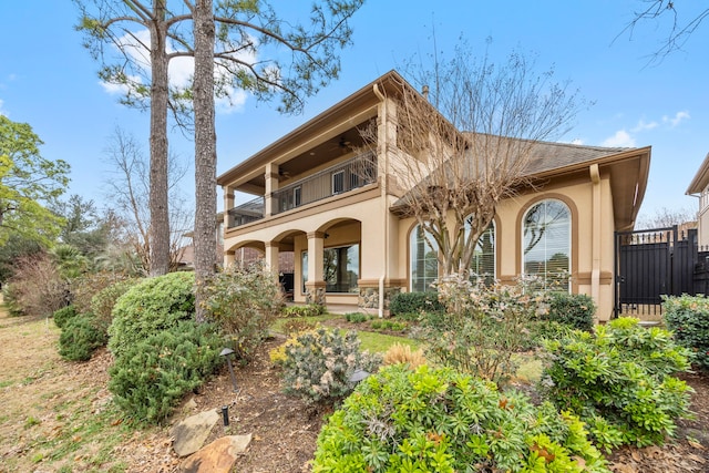 rear view of property featuring a balcony and covered porch