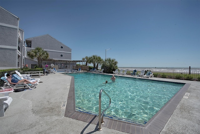 view of pool featuring a patio area and a water view