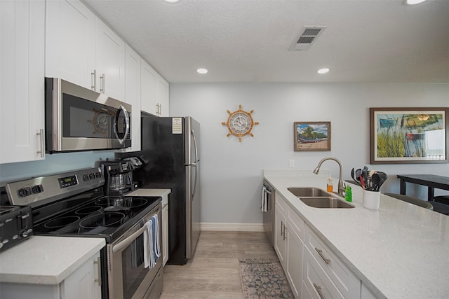 kitchen featuring appliances with stainless steel finishes, sink, and white cabinets