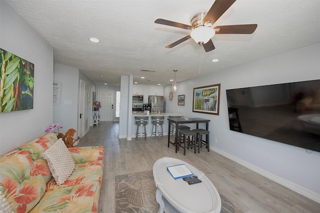 living room with light hardwood / wood-style flooring and a textured ceiling