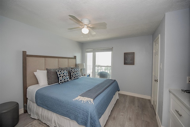 bedroom with ceiling fan, light hardwood / wood-style floors, and a textured ceiling