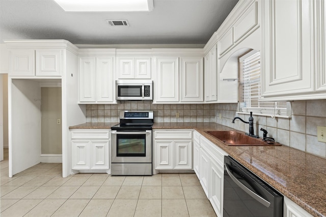 kitchen featuring white cabinetry, sink, light tile patterned floors, and stainless steel appliances