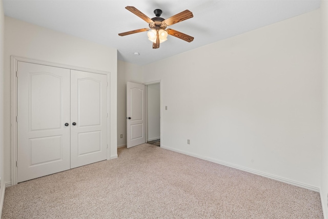 unfurnished bedroom featuring light colored carpet, ceiling fan, and a closet