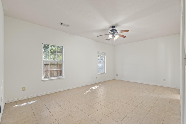 tiled spare room featuring ceiling fan