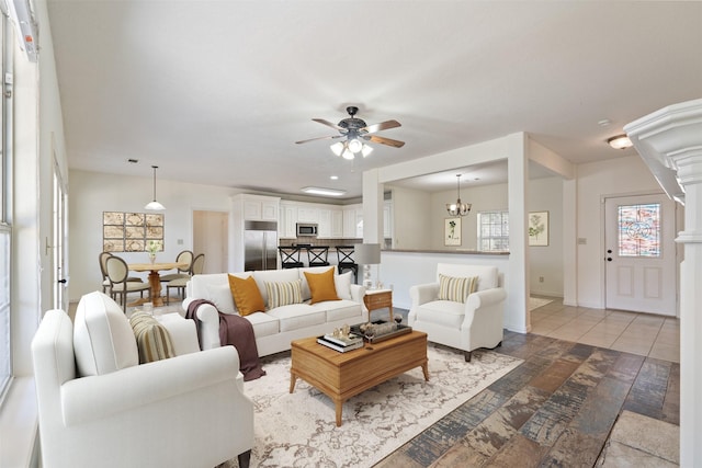 living room with ceiling fan with notable chandelier