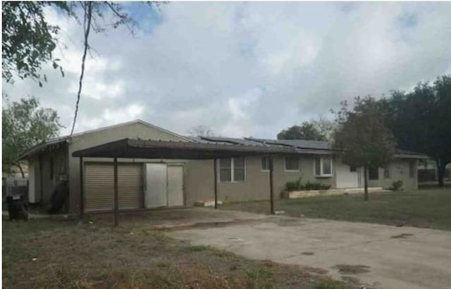 exterior space with a yard, a garage, and a carport