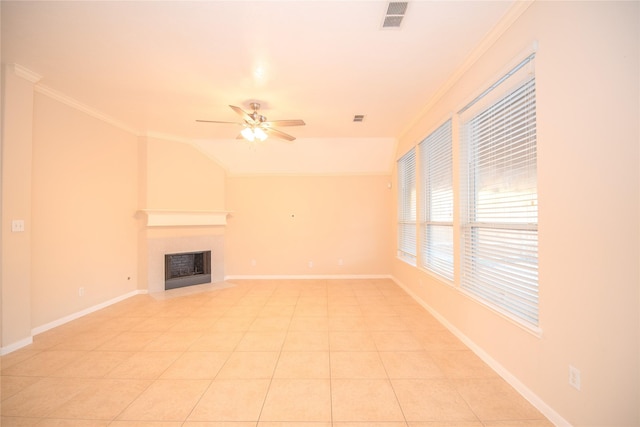 unfurnished living room featuring baseboards, visible vents, a ceiling fan, ornamental molding, and a fireplace