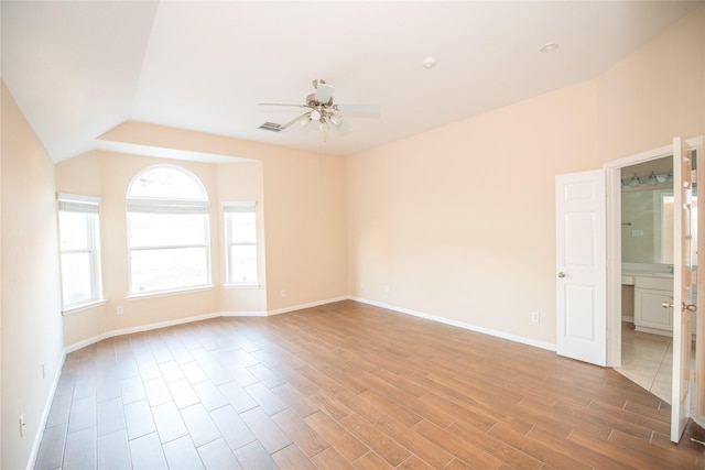 unfurnished room with lofted ceiling, visible vents, ceiling fan, wood finished floors, and baseboards