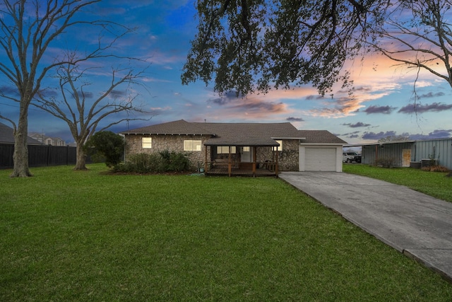 ranch-style house featuring a garage and a lawn