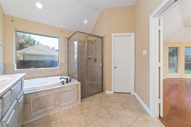 bathroom featuring vanity, shower with separate bathtub, tile patterned flooring, and vaulted ceiling