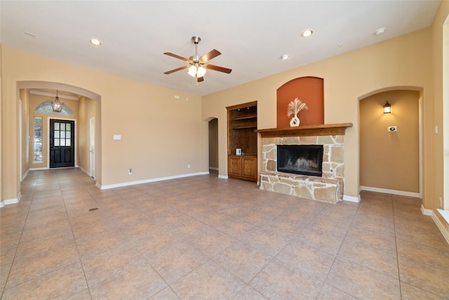 unfurnished living room featuring light tile patterned floors, a fireplace, and ceiling fan