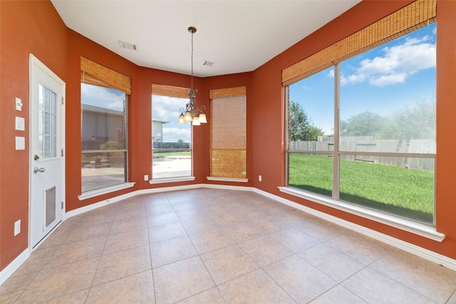 unfurnished dining area with tile patterned flooring, a chandelier, and a healthy amount of sunlight