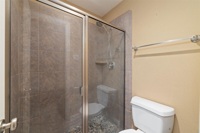 bathroom with a shower with door and toilet