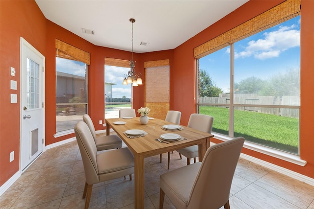 dining space featuring a chandelier and tile patterned flooring