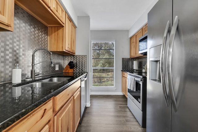 kitchen with dark wood-type flooring, sink, appliances with stainless steel finishes, dark stone counters, and decorative backsplash