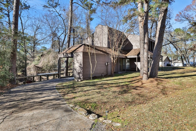 view of side of home featuring a carport and a lawn