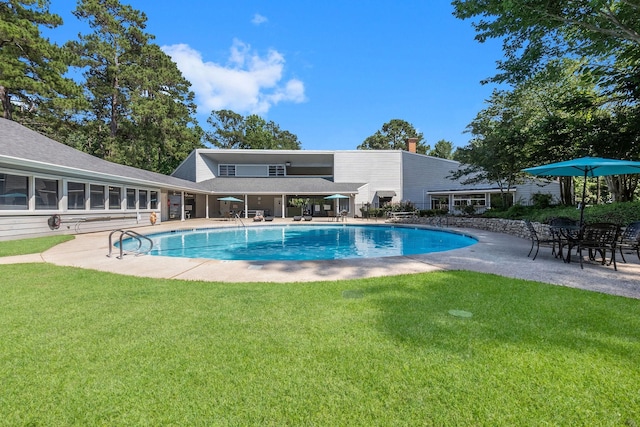 view of swimming pool featuring a lawn and a patio area