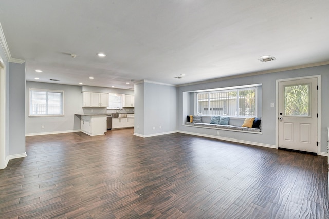 unfurnished living room featuring sink, dark wood-type flooring, and ornamental molding