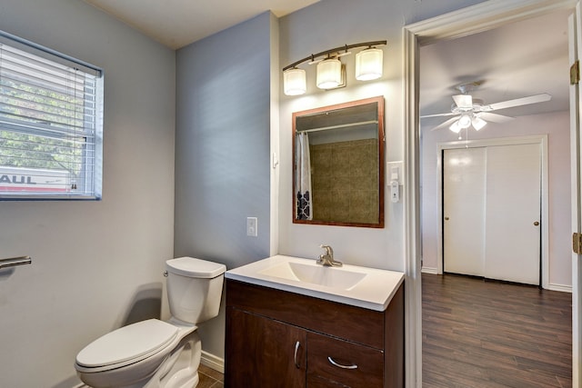 bathroom with ceiling fan, vanity, wood-type flooring, toilet, and walk in shower