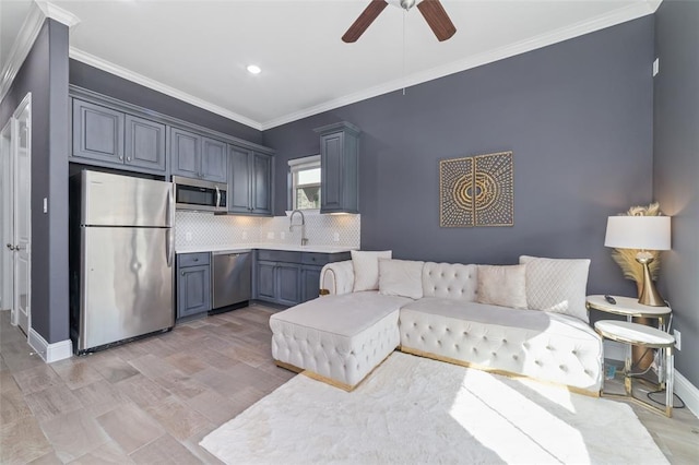 living room featuring sink, ornamental molding, and ceiling fan