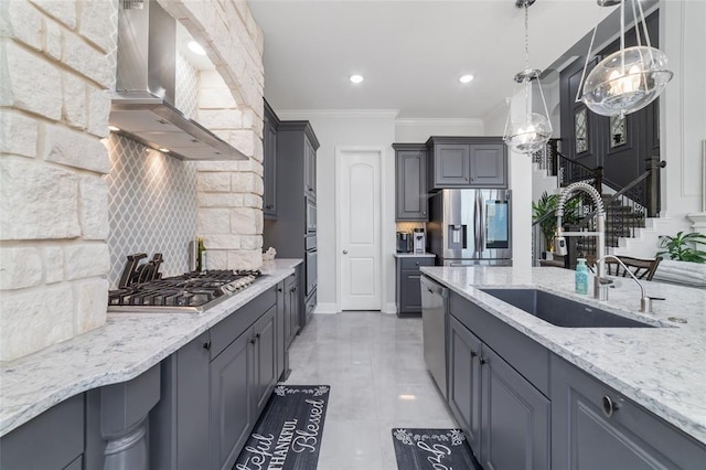 kitchen featuring gray cabinets, appliances with stainless steel finishes, tasteful backsplash, sink, and wall chimney exhaust hood