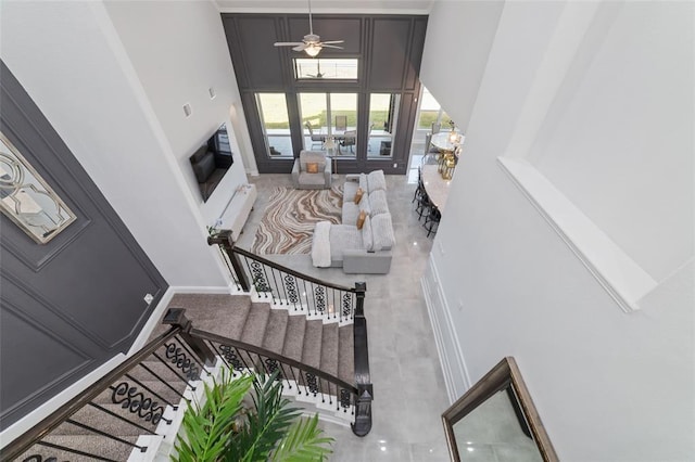 foyer with ceiling fan and a high ceiling