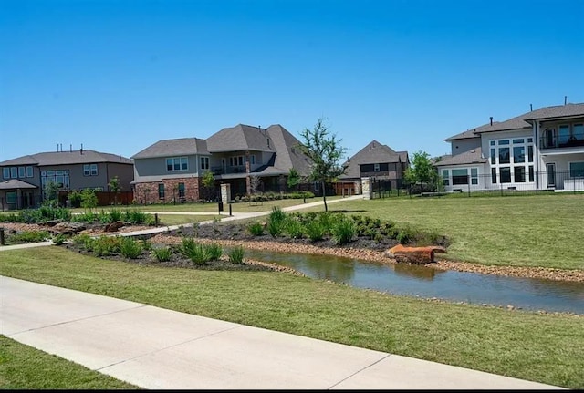 surrounding community with a water view and a yard