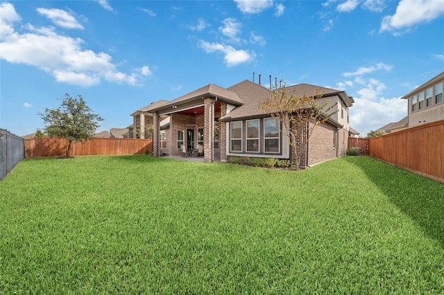 rear view of house featuring a yard