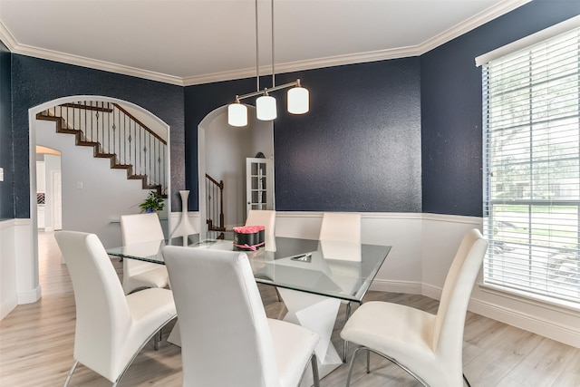 dining room with crown molding and light wood-type flooring