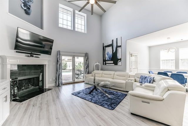 living room featuring light hardwood / wood-style flooring, a fireplace, and ceiling fan